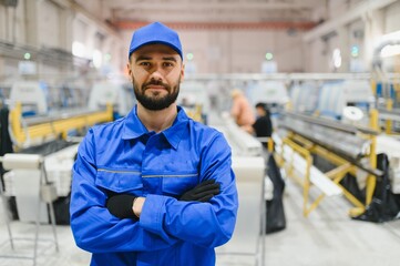 Portrait of factory worker with crossed arms in pvc and aluminum window and door production line