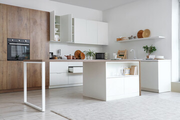 Interior of modern kitchen with table, counters and cupboards