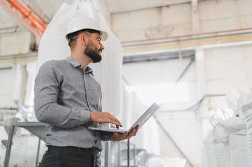 Engineer using laptop and inspecting production in flour mill