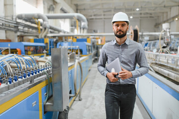 Industrial engineer walking and holding laptop in a factory