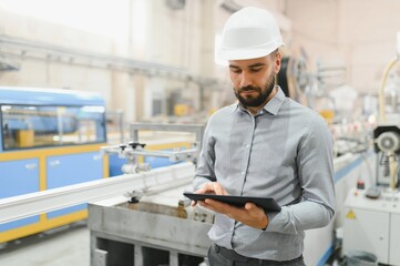 Supervisor controlling production line using digital tablet in pvc and aluminum window factory