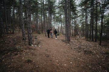Friends spend quality time together while exploring a tranquil forest path, creating lasting...