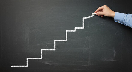 Hand drawing ascending staircase on chalkboard