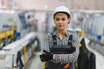 Female industrial worker smiling with crossed arms in pvc manufacturing plant