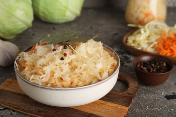 Bowl of tasty sauerkraut and ingredients on table. Closeup