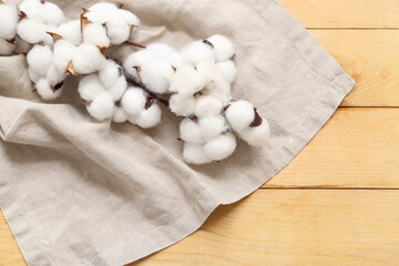 Beautiful cotton branch and napkin on wooden table