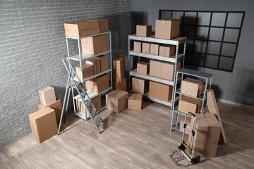 Interior of warehouse with shelf units, cardboard boxes and stepladder