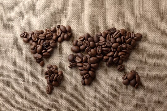 World map created with coffee beans on burlap background