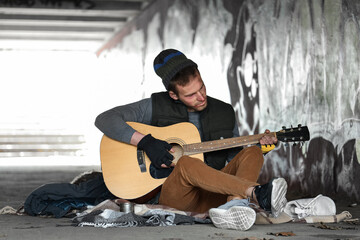 Homeless man playing guitar on street