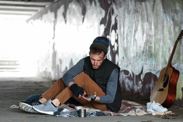 Homeless man counting coins on street