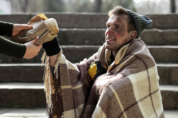 Homeless man receiving bread on street