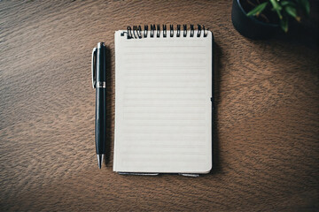 blank notebook and pen on wooden table 