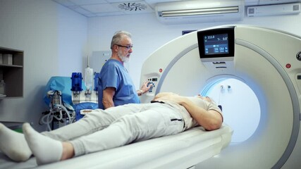 Doctor operationg CT machine in hospital. - Powered by Adobe