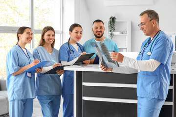 Medical interns studying x-ray scan of lungs at reception in clinic