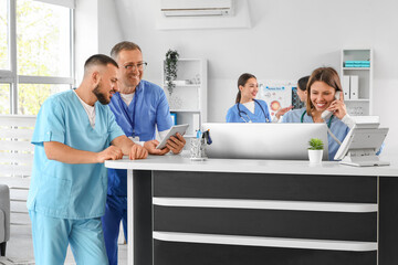Group of medical interns working at reception in clinic