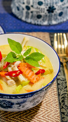 Aromatic Thai coconut curry soup with vibrant chilies, evoking Songkran zest and Lunar New Year...