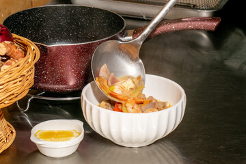 A ladle pours hearty, steaming stew into a porcelain bowl, evoking cozy autumn equinox gatherings and Hygge culinary traditions