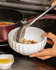 Steaming mushroom medley ladled by South Asian female hand, evoking Hygge coziness and obscure Umami Day celebrations