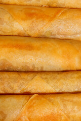 Golden crispy spring rolls lined in harmony, evoking the Lunar New Year feast, echoing hidden...