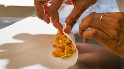 Crafting zesty shrimp spring rolls, Asian cuisine ritual, nimble brown-skinned hands, Lunar New Year, culinary artistry