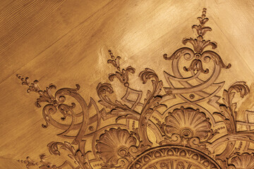 Close-up of an ornate wooden ceiling design featuring intricate carved motifs