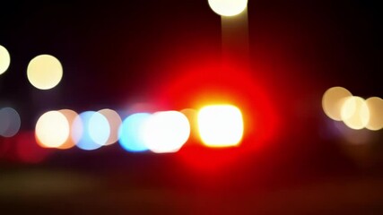 Out of focus flashing police lights on the car. Close-up. The lights of the patrol car are blurred. Glowing ambulance lights at night. Emergency assistance.
