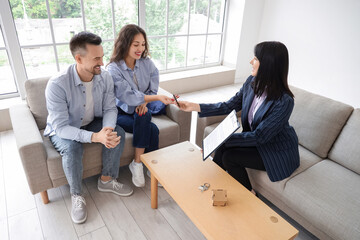 Female real estate agent selling house to couple in room
