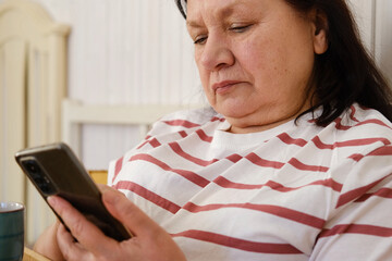 Senior woman having breakfast sitting in bed, drinking tea, enjoying her morning at home. Old lady...