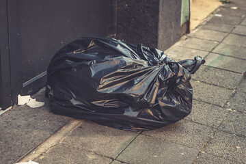 Urban alleyway littered with discarded refuse under soft afternoon light