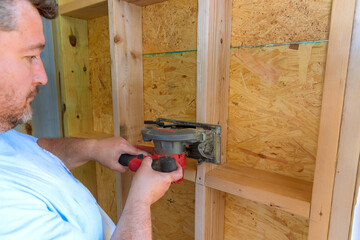 Woodworker uses saw cut router to shape wooden panels in home workshop, demonstrating skill...
