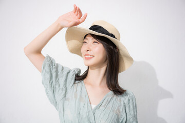 Closeup of a woman in summer clothes wearing a straw hat and worrying about a glaring sunburn White...