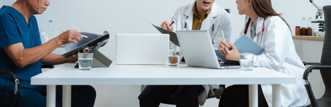 Medical, meeting and laptop for team in office in discussion, brainstorming and planning. Doctor, nurse and computer on desk, teamwork or workshop for data analytics. - Powered by Adobe