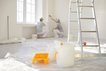 Fototapeta na wymiar Painters team working with paint rollers, construction workers, professional service men wearing uniform for preparation, painting, tasks for room repair, color wall in apartment flat, renovation