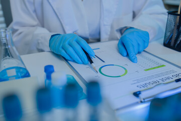 a female chemist is testing various liquid compounds in a lab, a scientist is doing research on the...