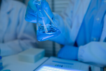 when in a lab, scientists wear lab coats, rubber gloves, and safety goggles, two chemists are...