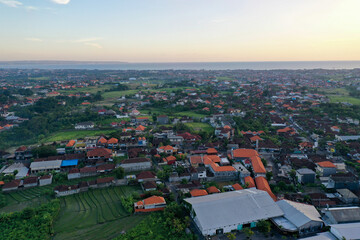 Fototapeta premium Drone View of Tiled Balinese Roofs Blending with Island Greenery