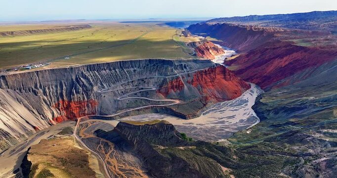 Aerial shot of the spectacular Anjihai Grand Canyon and winding river with colorful geological formations in Xinjiang, China.