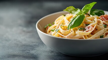 A mouth-watering plate of creamy fettuccine pasta, beautifully garnished with fresh basil and herbs, perfect for food lovers and culinary enthusiasts to enjoy.