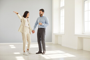 Fototapeta premium Cheerful family couple celebrating house ownership by dreaming about living space and planning future together in new home. Reflects teamwork, hope, and the joy of starting a new chapter.