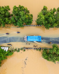 Elevated view of a flood-hit village with houses partially underwater in brown floodwate
