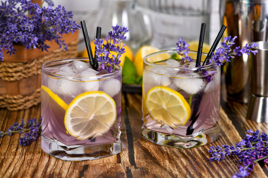 Margarita cocktail with lavender flavor. Garnished with lemon wedges and lavender sprigs