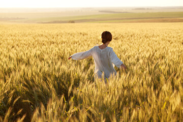 Woman in a wheat field on a summer evening.
