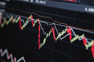 A close-up photograph of a digital stock market trading chart on a black background. The chart displays red and white candlestick bars showing price movements over time.