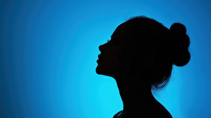 A woman's silhouette against a blue background, with her hair tied back in a bun.