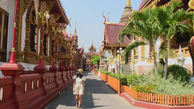 Chiang Mai, Thailand - 16th march, 2024: Female tourist walking inside Wat Saen Mueang Ma Luang temple complex, Chiang Mai, Thailand, exploring traditional Lanna Buddhist architecture in sunny hot day