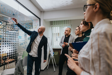 A group of business associates engaging in a collaborative meeting to analyze and discuss...