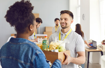 Volunteer man giving box to african american woman, charitable meal foundation, donation to needy, charity, separating donations stuff, basic need provisions, free meal for people in need, food bank