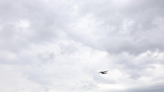 Old military airplane Lockheed C130 Hercules flies low under heavy storm clouds creating dramatic tension retro war vibes and cinematic atmosphere filled with motion power history and incoming turbule