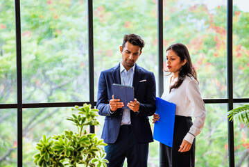 Chasing project deadline indoors, Indian corporate team discusses work using tablet in office