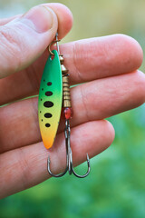 Image of a hand with a fishing lure. Spinning rod, sport fishing